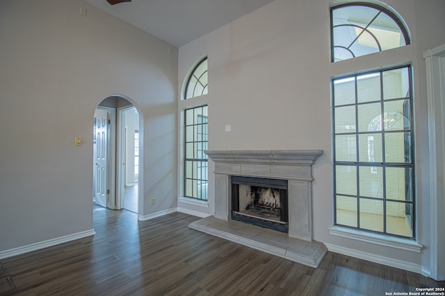 unfurnished living room featuring dark hardwood / wood-style floors and high vaulted ceiling