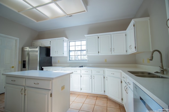 kitchen with white dishwasher, white cabinets, sink, stainless steel fridge, and a kitchen island