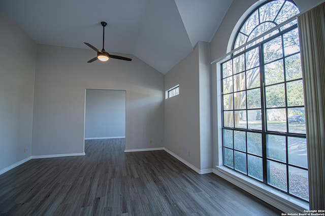 spare room featuring dark hardwood / wood-style flooring, ceiling fan, plenty of natural light, and lofted ceiling