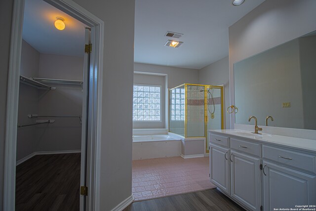 bathroom featuring hardwood / wood-style floors, vanity, and independent shower and bath