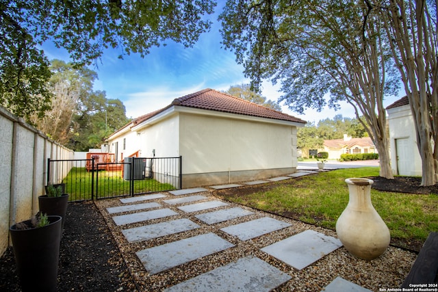 view of property exterior with central air condition unit and a lawn