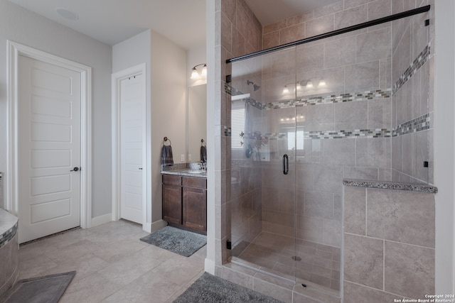 bathroom with tile patterned floors, vanity, and a shower with shower door