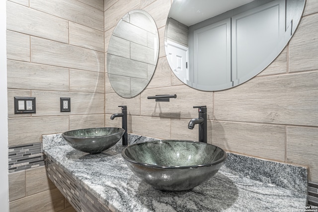 bathroom with vanity and tile walls