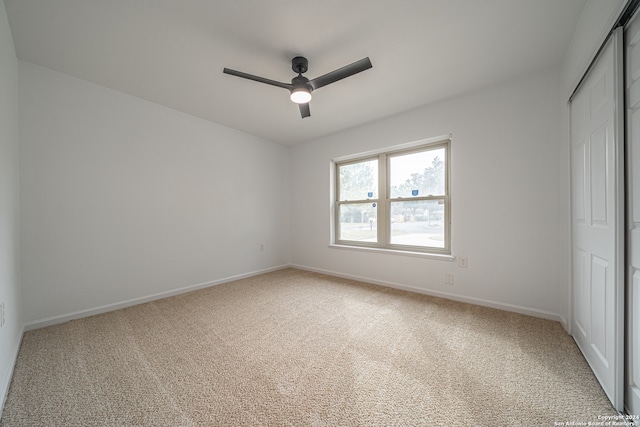 unfurnished bedroom featuring carpet flooring, ceiling fan, and a closet