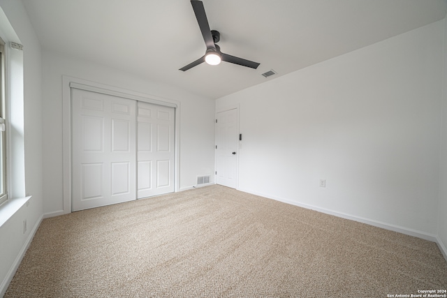 unfurnished bedroom with carpet flooring, ceiling fan, and a closet