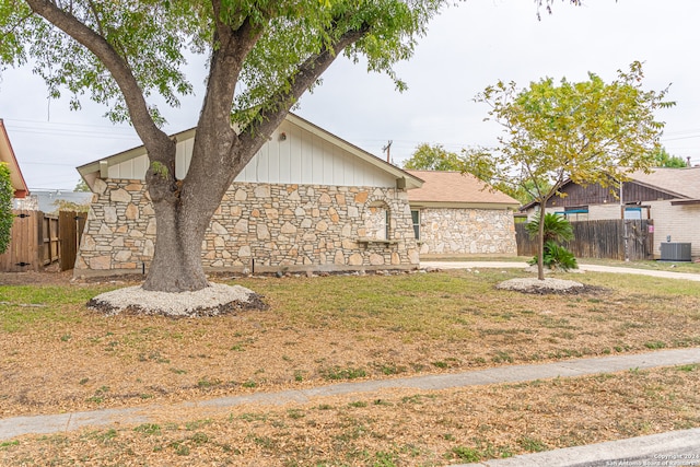 view of front of property featuring central AC unit and a front yard