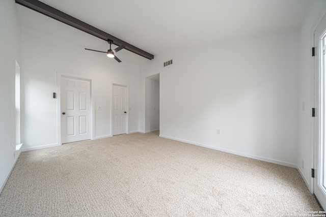 unfurnished bedroom featuring carpet, lofted ceiling with beams, and ceiling fan