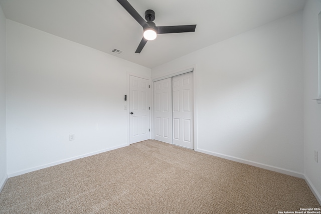 unfurnished bedroom with ceiling fan, carpet floors, and a closet