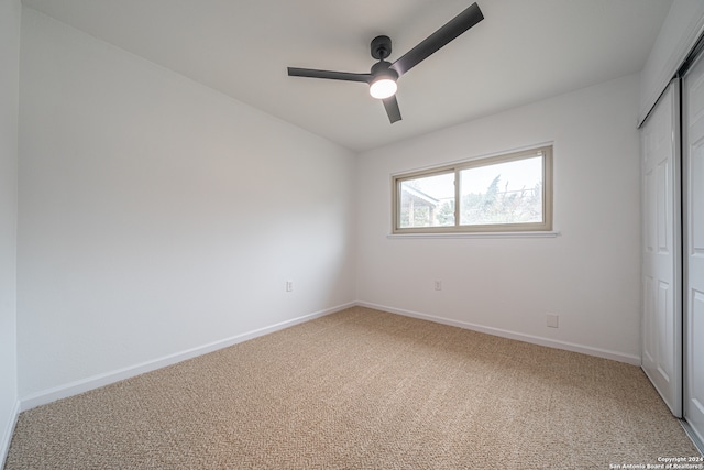 unfurnished bedroom with carpet flooring, ceiling fan, and a closet