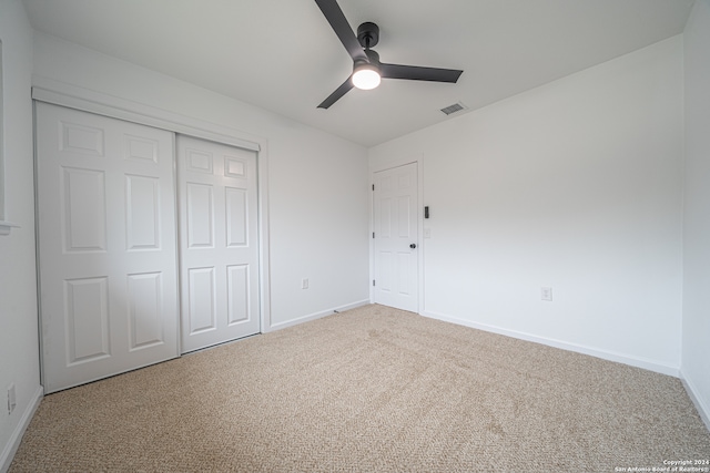 unfurnished bedroom featuring carpet flooring, ceiling fan, and a closet