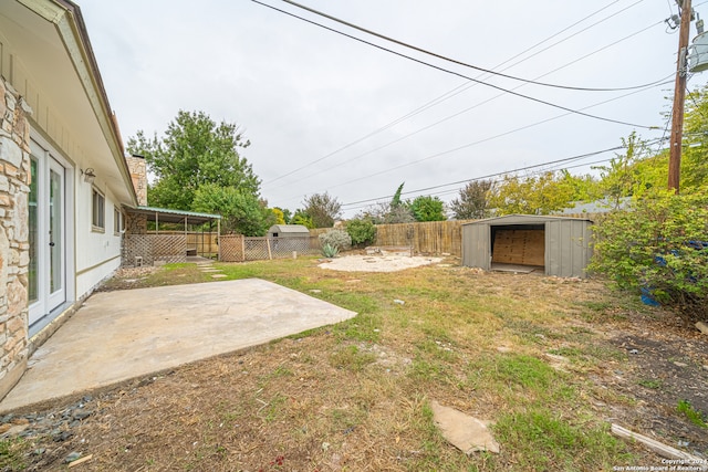 view of yard with a storage shed and a patio area