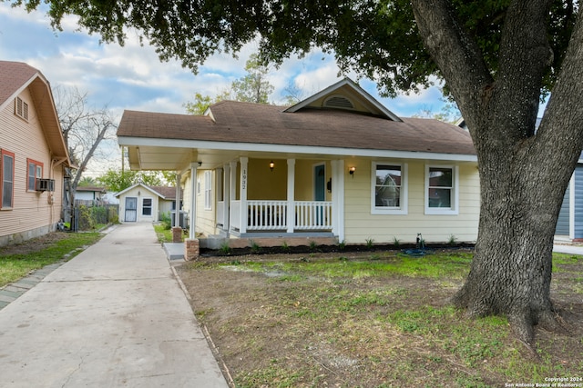 bungalow with a porch and a storage shed