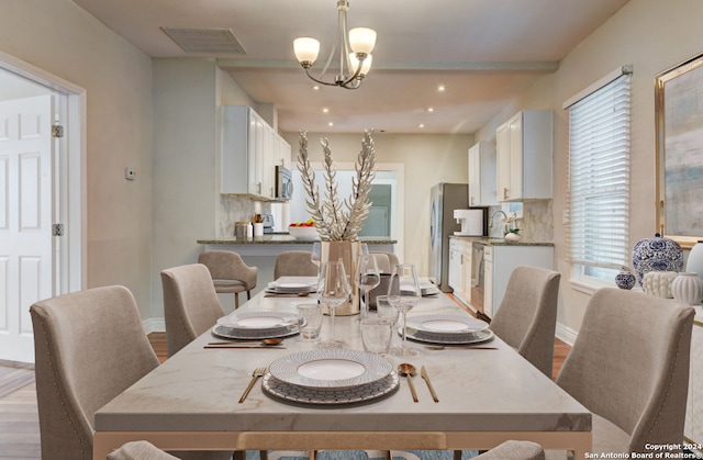 dining area with a chandelier, hardwood / wood-style flooring, and sink