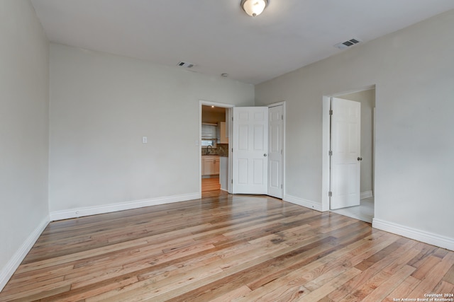 unfurnished room with sink and light hardwood / wood-style floors