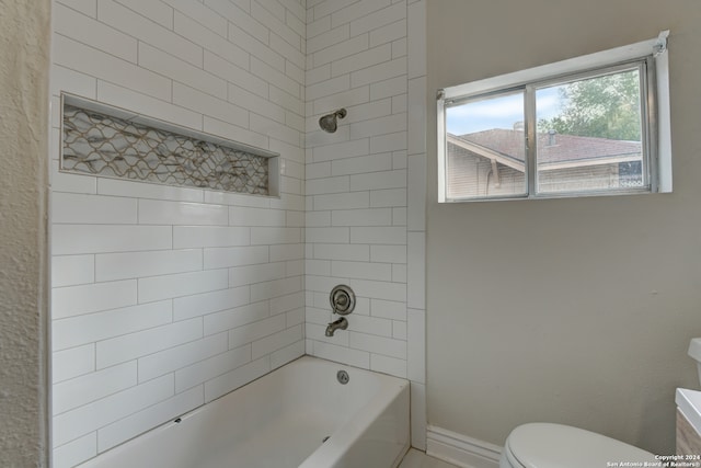 bathroom with toilet and tiled shower / bath