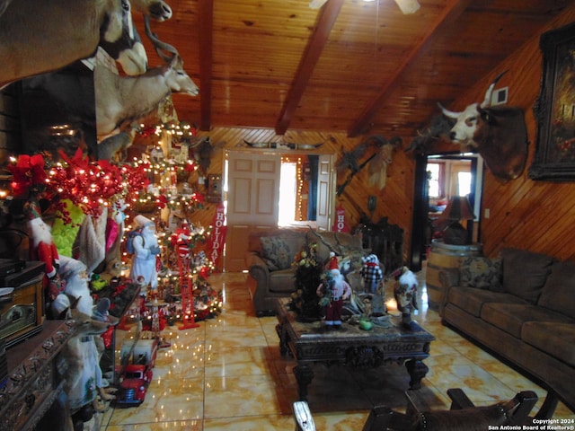 living room featuring wood walls, ceiling fan, light tile patterned floors, beam ceiling, and wood ceiling