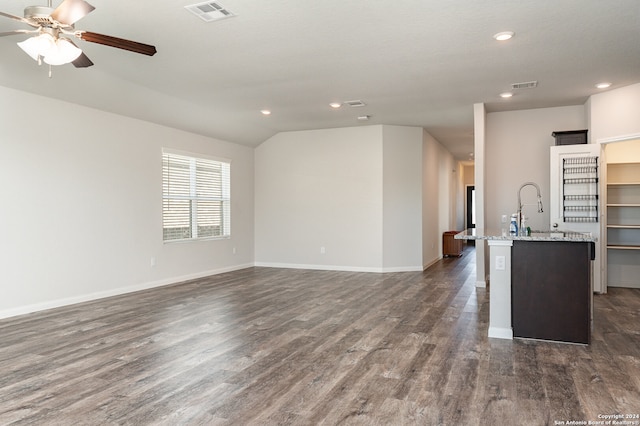 interior space featuring dark hardwood / wood-style floors, ceiling fan, sink, and vaulted ceiling