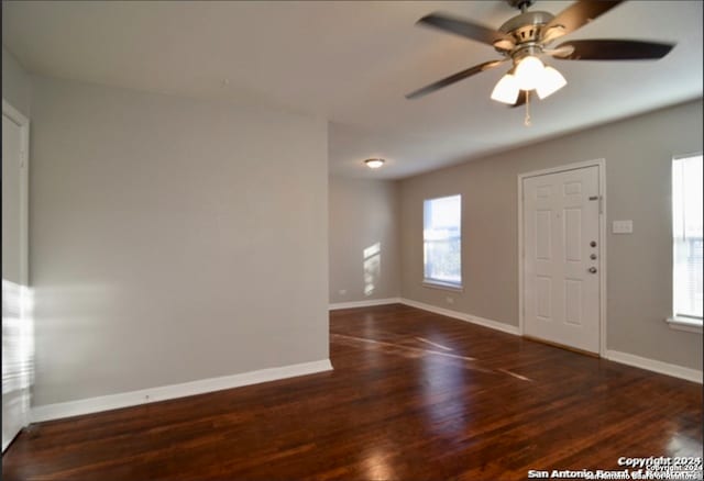 entrance foyer with ceiling fan, a healthy amount of sunlight, and dark wood-type flooring