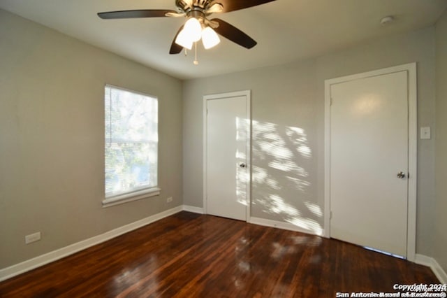 unfurnished bedroom featuring ceiling fan and dark wood-type flooring