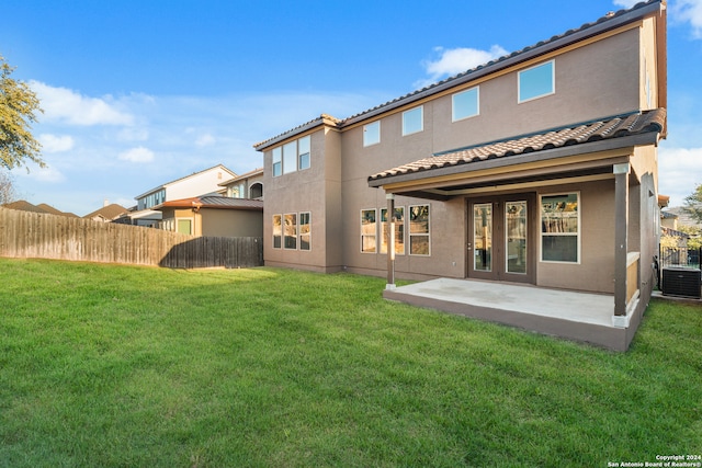 rear view of house featuring a patio area, a yard, and central AC