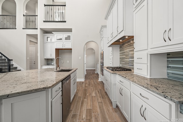 kitchen featuring appliances with stainless steel finishes, white cabinetry, sink, and tasteful backsplash