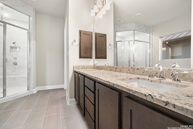 bathroom featuring tile patterned flooring, a shower with door, and vanity