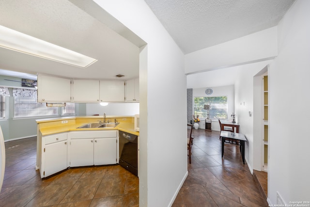 kitchen featuring sink, a textured ceiling, black dishwasher, white cabinetry, and kitchen peninsula