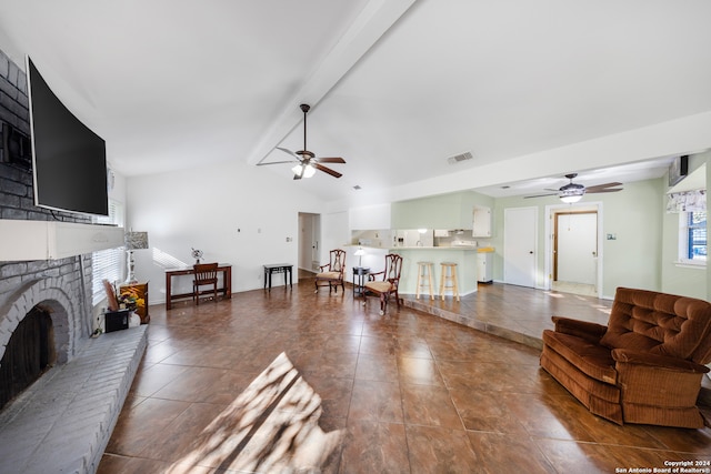 living room featuring tile patterned floors, ceiling fan, lofted ceiling with beams, and a brick fireplace