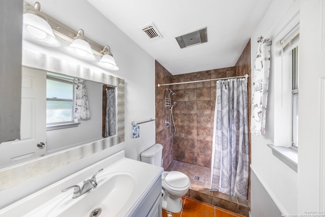 bathroom with tile patterned flooring, vanity, toilet, and walk in shower