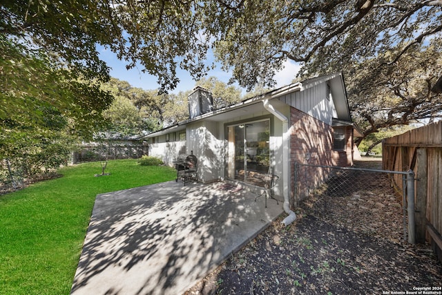 rear view of property featuring a patio area and a yard