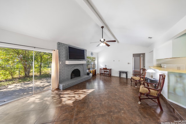 living room featuring lofted ceiling with beams, a brick fireplace, and ceiling fan