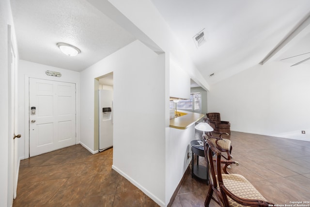 hallway featuring a textured ceiling and dark tile patterned floors