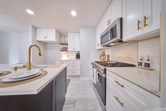 kitchen featuring tasteful backsplash, white cabinetry, and appliances with stainless steel finishes