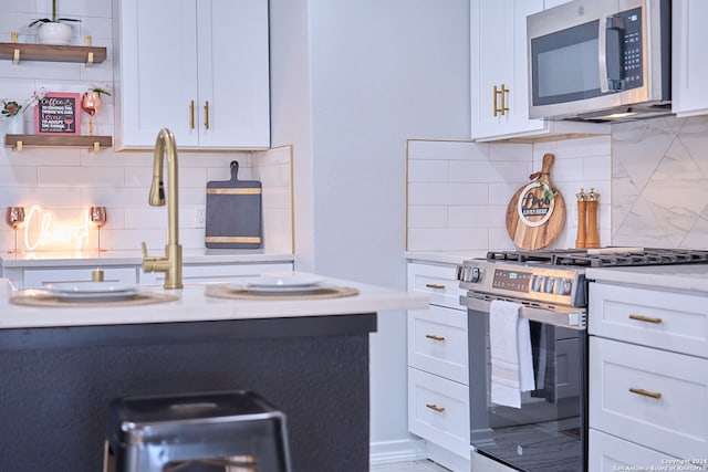 kitchen with white cabinets, stainless steel appliances, and tasteful backsplash