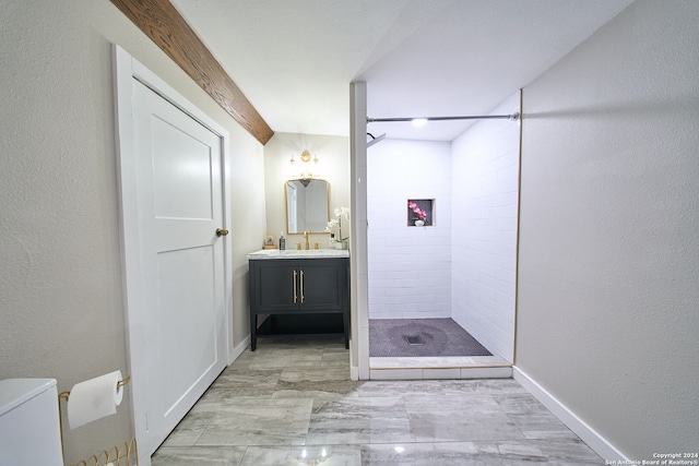 bathroom featuring toilet, vanity, and tiled shower