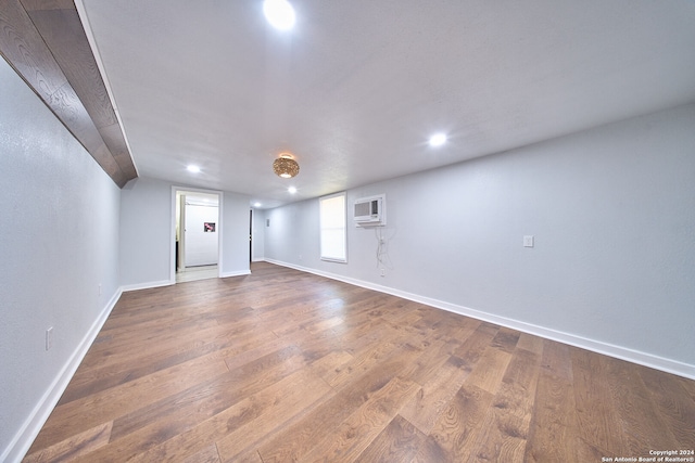 spare room featuring a wall mounted AC and dark hardwood / wood-style flooring