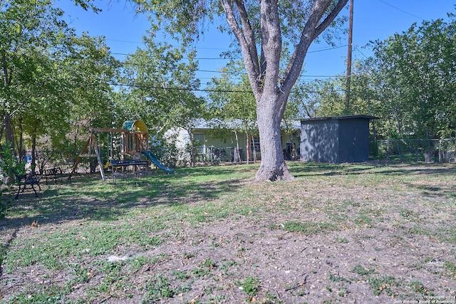 view of yard featuring a playground and a storage shed