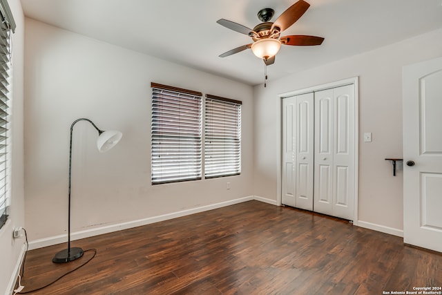 unfurnished bedroom featuring a closet, dark hardwood / wood-style floors, and ceiling fan