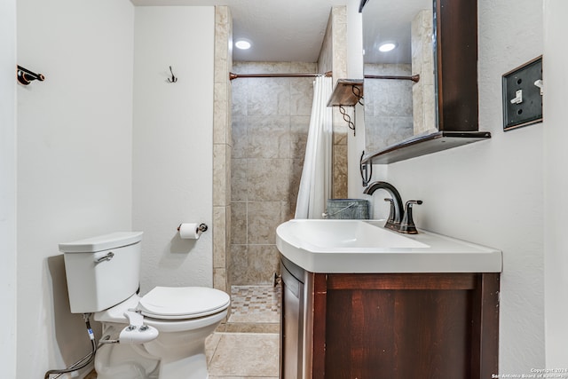 bathroom with a shower with curtain, vanity, toilet, and tile patterned floors