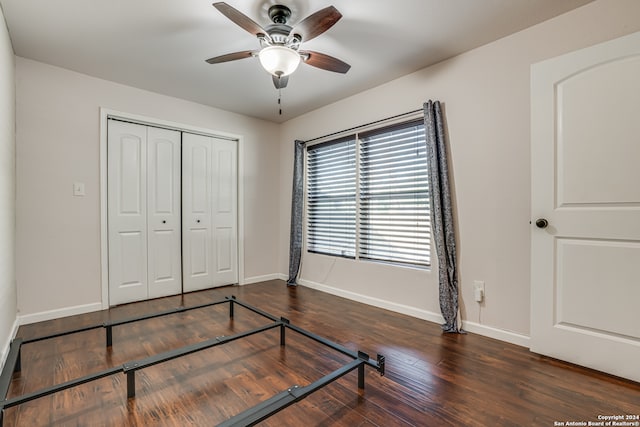 bedroom with dark hardwood / wood-style floors, ceiling fan, and a closet