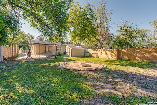 view of yard with a patio area, a shed, and a fire pit