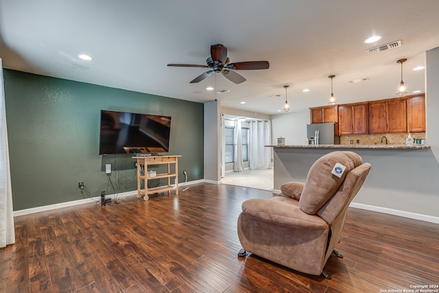 living room featuring ceiling fan and dark hardwood / wood-style flooring