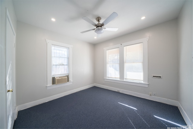 unfurnished room with ceiling fan, dark carpet, and cooling unit