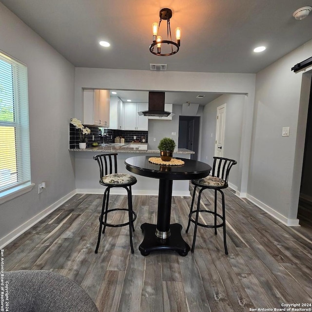 dining room featuring dark hardwood / wood-style floors and an inviting chandelier