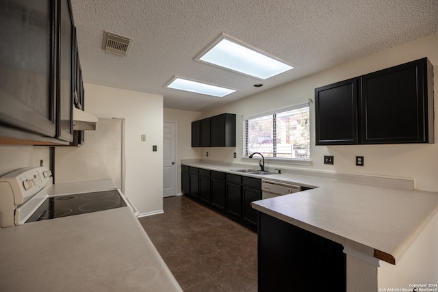 kitchen with a textured ceiling, kitchen peninsula, electric stove, and sink