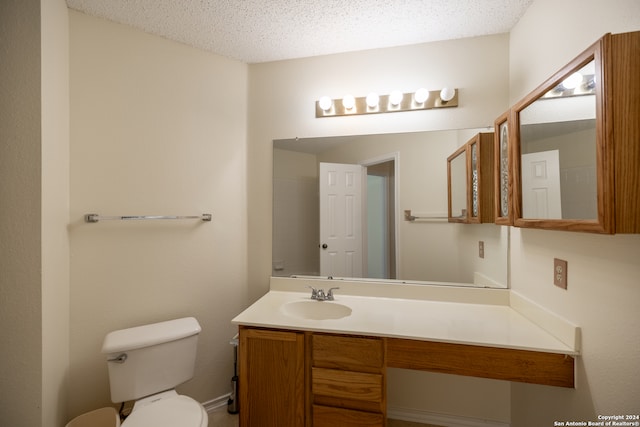 bathroom featuring vanity, toilet, and a textured ceiling