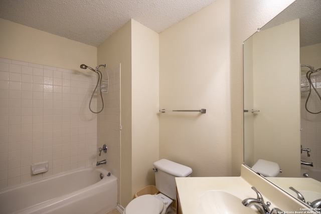 full bathroom with a textured ceiling, vanity, toilet, and tiled shower / bath