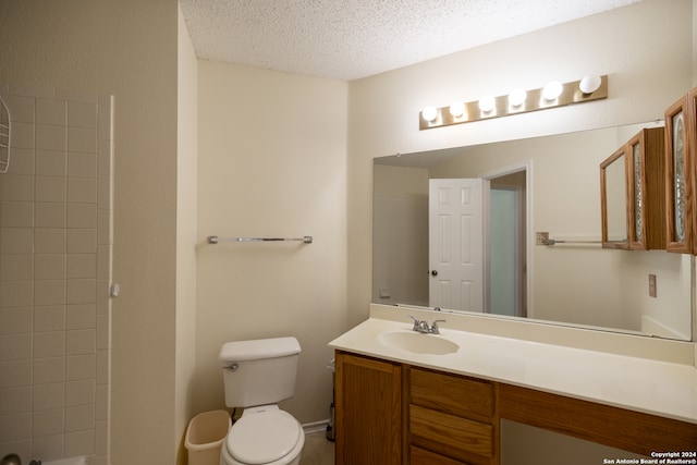 bathroom featuring vanity, a textured ceiling, toilet, and walk in shower