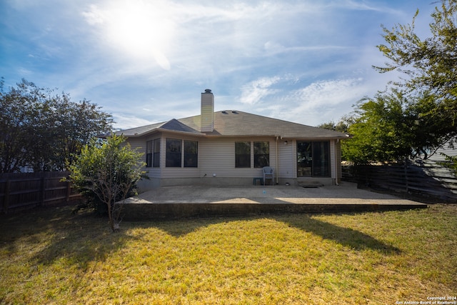 rear view of house with a yard and a patio area