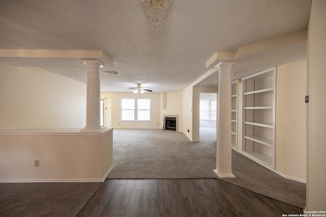 unfurnished living room featuring hardwood / wood-style floors, ceiling fan, ornate columns, and a textured ceiling